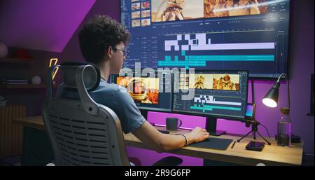 Junger Redakteur, Videofilmer, bearbeitet Tonspuren für Filme mit Astronauten, arbeitet im Home Office. Filmmaterial und Programmoberfläche mit Tools auf Computer und großem digitalen Bildschirm. Postproduction-Konzept. Stockfoto