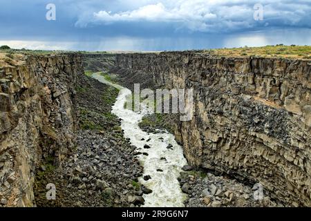 Der Malad River schlängelt sich durch die berühmte Malad Gorge unter einem dramatischen Himmel im Süden Idahos. Stockfoto