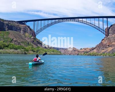 Ein junger Mann paddelt auf dem Snake River zur Perrine Bridge in Twin Falls, Idaho. Stockfoto