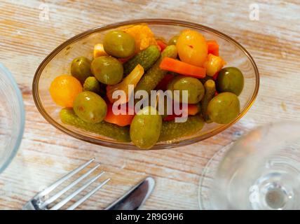 Grüne Oliven serviert mit Gurke, Karotte, Knoblauch und Zwiebeln Stockfoto