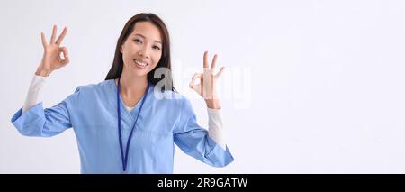 Asiatische Ärztin mit OK-Geste auf weißem Hintergrund und Platz für Text Stockfoto