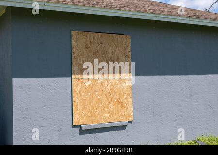 Sperrholzläden zum Hurrikanschutz von Hausfenstern. Schutzmaßnahmen vor Naturkatastrophen in Florida Stockfoto