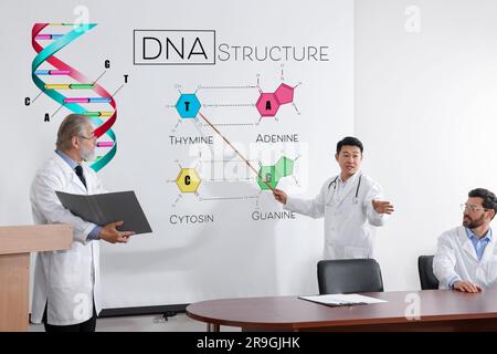 Professoren halten Vorlesungen über DNA-Struktur im Konferenzraum. Projektionsleinwand mit Illustration und Informationen Stockfoto