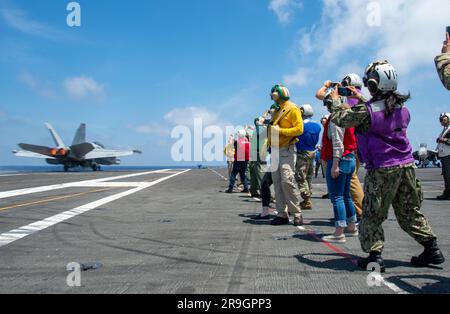 230624-N-JO823-1293 SÜDCHINESISCHE SEE (24. Juni 2023) amerikanische und multinationale Verteidigungsattachés beobachten den Flugbetrieb auf dem Flugdeck der USA Der einzige vorausgesetzte Flugzeugträger der Navy, USS Ronald Reagan (CVN 76), während einer Schifffahrt im Südchinesischen Meer, 24. Juni 2023. Ronald Reagan, das Flaggschiff der Carrier Strike Group 5, stellt eine kampfbereite Truppe bereit, die die Vereinigten Staaten schützt und verteidigt und Bündnisse, Partnerschaften und kollektive maritime Interessen in der Region Indo-Pazifik unterstützt. (USA Marinebild von Mass Communication Specialist 3. Klasse Natasha ChevalierLosada) Stockfoto