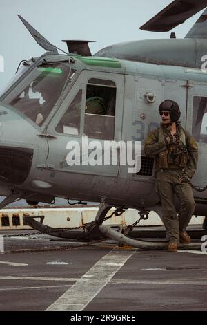 USA Marinekorps Sergeant Christopher Williams, ein UH-1Y-Giftbesatzungschef mit Marine Medium Tiltrotor Squadron 265 (rein.), 31. Marine Expeditionary Unit, beobachtet UH-1Y-Giftpiloten bei der Durchführung ihrer Sicherheitskontrollen vor einem speziellen Waffenlieferungstraining im Korallenmeer, 22. Juni 2023. Durch die spezielle Schulung zur Waffenlieferung wurde die Waffenkompetenz des Geschwaders in der nahen Luftunterstützung erhöht. Die MEU des Jahres 31. wird an Bord von Schiffen der America Amphibious Ready Group im Flottenbereich 7. eingesetzt, um die Interoperabilität mit Verbündeten und Partnern zu verbessern und als bereichsfertige Reaktion zu dienen Stockfoto