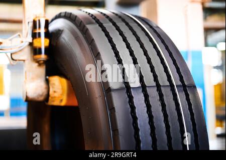 Fertiger Reifen mit gelben und rosafarbenen Farblinien auf der Stange im Werk Stockfoto