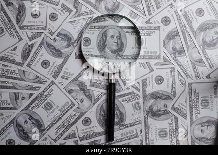Lupe auf einem Haufen von hundert US-Dollar Stockfoto