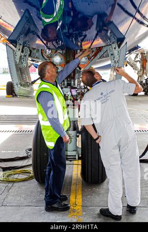 Die Ingenieure inspizieren das Laufwerk beim ersten Test mit einem Flugzeug des Typs Boeing 787 Dreamliner, das die südliche Hemisphäre als Gäste von Air New Zealand besucht. Stockfoto