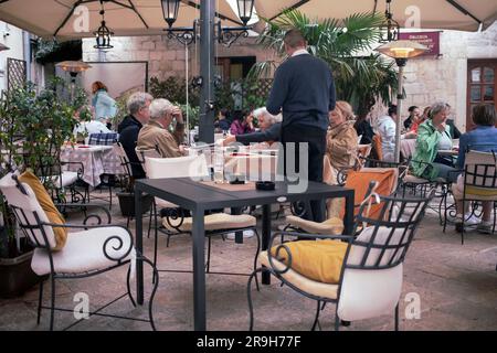 Montenegro, 13. April 2023: Ein Café im Freien mit Gästen am Flour Square (Trg od brašna) in der Altstadt von Kotor Stockfoto