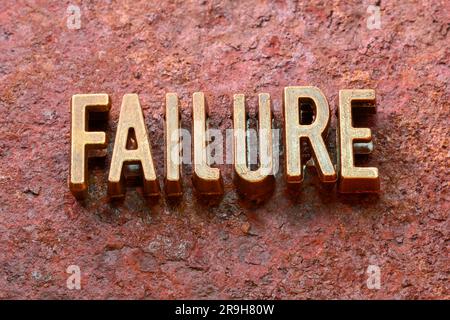 Versagenswort aus metallischen Buchstaben auf rostiger Oberfläche Stockfoto