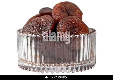 Getrocknete Aprikosen, isoliert auf weißem Hintergrund. Dunkel getrocknete Aprikosen in einer Glasschüssel. Diätkost. Schließen Stockfoto