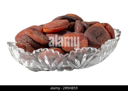 Getrocknete Aprikosen, isoliert auf weißem Hintergrund. Dunkel getrocknete Aprikosen in einer Glasschüssel. Diätkost. Schließen Stockfoto