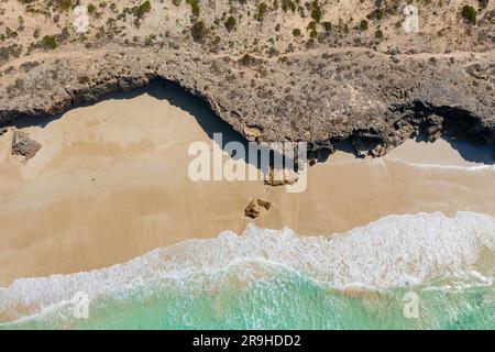 Luftaufnahme auf eine zerklüftete Küstenklippe mit Wellen an einem Sandstrand unten am Mary Ellis Wreck Beach auf der Halbinsel Eyre in Südaustralien Stockfoto