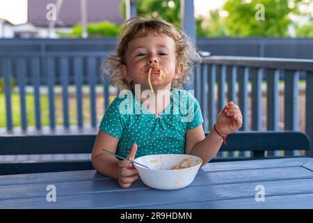 Das Kind isst Spaghetti-Pasta. Selektiver Fokus. Essen. Stockfoto