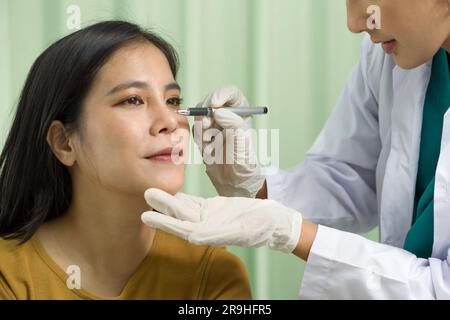 Plastisch-chirurgisches Gesichtskonzept. Frau mittleren Alters in der Sprechstunde beim Chirurgen, Arzt macht Markierungen im Gesicht der Patientin. Schließen Stockfoto