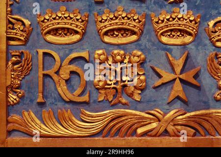 Goldene Dekoration mit maltesischem Kreuz, Monogramm „RC“ und anderen Symbolen an der Wand in St. John's Co-Cathedral in Valletta, Malta Stockfoto