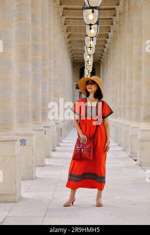 Zwischen den Säulen im Palais Royal in einem russischen Bauernkleid, eine glamouröse, reife Asiatin in Paris Stockfoto