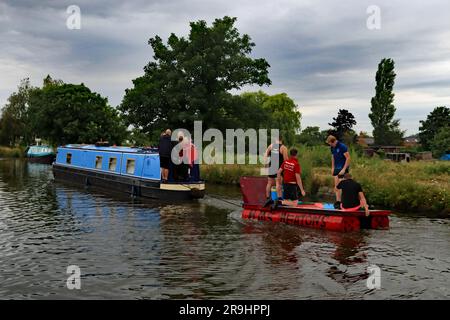 Das Floß vom Heatons Bridge Pub wird von einem Schmalboot nach dem Burscough Floß-Rennen entlang des L- und L-Kanals zum Startplatz zurückgeschleppt Stockfoto