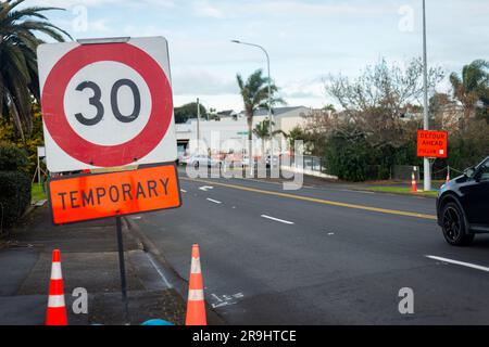 Temporäres 30km-Geschwindigkeitsbegrenzungsschild und Umleitungsschild am Straßenrand. Straßenarbeiten auf Auckland Road. Stockfoto