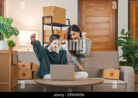 Verkaufen Sie Produkte online an Geschäftsinhaber. Konzentrieren Sie sich auf das Gesicht von zwei Frauen, indem Sie einem Freund Freude machen, dessen Online-Verkäufe seine Erwartungen übertrafen Stockfoto