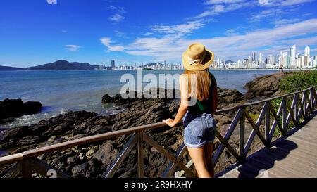 Urlaub in Balneario Camboriu, Santa Catarina, Brasilien. Panoramablick auf ein wunderschönes weibliches Model mit Blick auf die Skyline von Balneario Camboriu auf Atlan Stockfoto