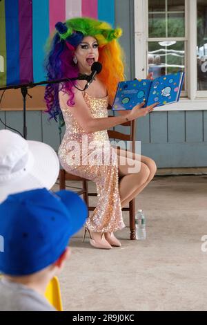 Ein Drag Performer liest ein Buch zu Kindern mit dem Namen Einpassen, über Inklusivität. In Lewisboro, Westchester, bei einer Pride-Veranstaltung. Juni 2023. Stockfoto