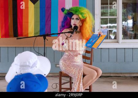 Ein Drag Performer liest ein Buch zu Kindern mit dem Namen Einpassen, über Inklusivität. In Lewisboro, Westchester, bei einer Pride-Veranstaltung. Juni 2023. Stockfoto