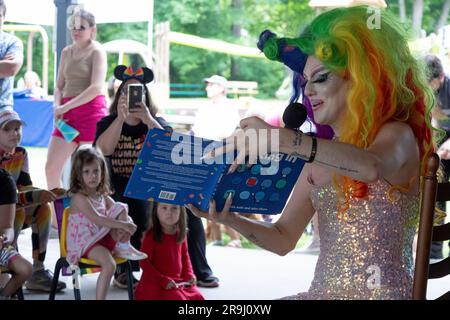 Ein Drag Performer liest ein Buch zu Kindern mit dem Namen Einpassen, über Inklusivität. In Lewisboro, Westchester, bei einer Pride-Veranstaltung. Juni 2023. Stockfoto