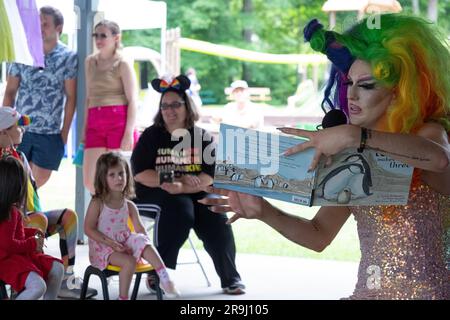 Ein Drag Performer liest ein Buch zu Kindern mit dem Namen Einpassen, über Inklusivität. In Lewisboro, Westchester, bei einer Pride-Veranstaltung. Juni 2023. Stockfoto