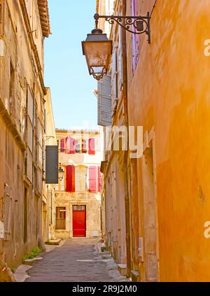 Es ist leicht, sich im Labyrinth der engen mittelalterlichen Gassen des alten Arles zu verirren und die für provenzalische Häuser typischen bunten Fensterläden und Türen zu beobachten Stockfoto