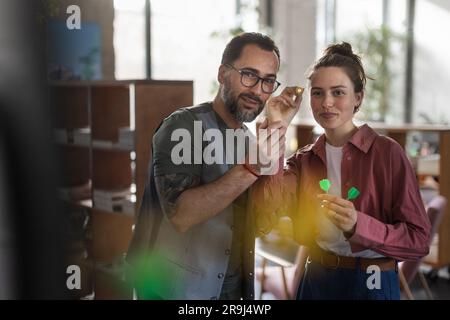 Glückliche Kollegen, die Pause bei der Arbeit haben und Darts spielen. Stockfoto