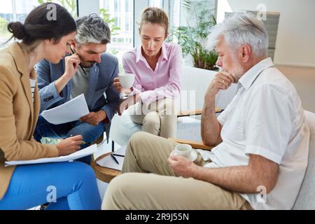 Engagierte Geschäftskollegen diskutieren in der Lounge über Dokumente Stockfoto