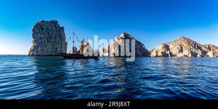 Panoramablick auf den Bogen von Cabo San Lucas und ein Piratenschiff, das den Golf von Kalifornien anfährt, das das Meer von Cortez mit dem Pazifischen Ozean verbindet. Stockfoto