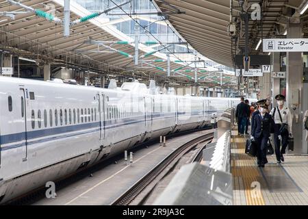 Tokio, Japan – April 2023; Blick von einem der Bahnsteige, auf dem sich das neue Personal des Schichtzugs nähert und auf dem nächsten Bahnsteig auf den Shinkansen-Zug wartet Stockfoto