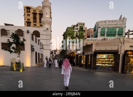 Jeddah, Saudi-Arabien - Menschen in traditioneller Stoffbekleidung gehen vor der Al Ma'amar Moschee in der Altstadt von Jeddah Al-Balad in Saudi-Arabien Stockfoto