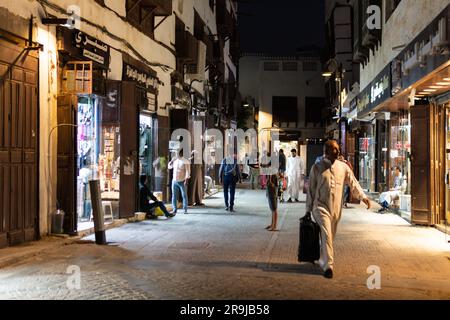 Jeddah, Saudi-Arabien - Januar 26 2023: Ein arabischer Mann spaziert nachts in den Straßen des Souks von Dschidda, der traditionellen Altstadt von Al-Balad in Saudi-Arabien Stockfoto