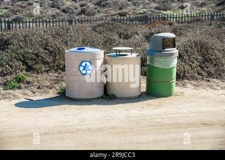 Eine Reihe von Recyclingbehältern in einem Park an einem sonnigen Herbsttag Stockfoto