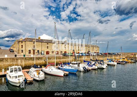 Lossiemouth Moray Scotland Pitgaveny Street die restaurierten Gebäude und kleinen Boote im Hafen oder Jachthafen im Frühsommer Stockfoto