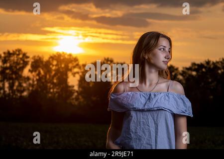 Ein junges Mädchen im Hintergrund des Sonnenuntergangs. Stockfoto
