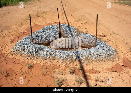 In einer neuen Unterteilung aus Lehmboden wurde ein Gullydeckel für den Regenablauf installiert. Stockfoto