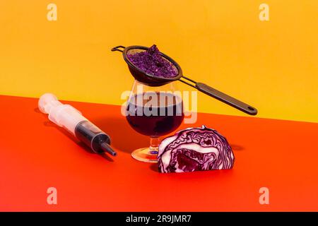 Zusammensetzung von Glas mit Sieb und Spritze gefüllt mit hausgemachtem Rotkohlsaft vor hellem Hintergrund Stockfoto
