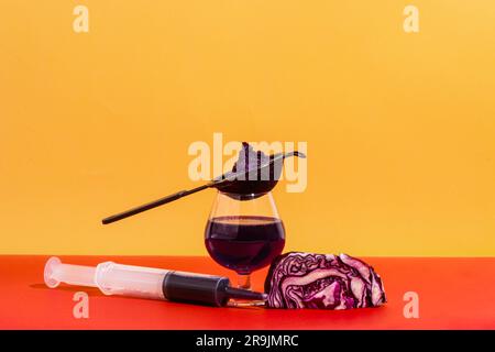 Zusammensetzung von Glas mit Sieb und Spritze gefüllt mit hausgemachtem Rotkohlsaft vor hellem Hintergrund Stockfoto