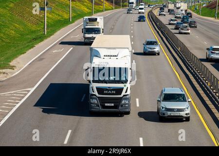 Minsk, Belarus - 10. Mai 2022: Eine Straße mit starkem Verkehr in beide Richtungen. Im Vordergrund befindet sich ein großer Lkw. Vorderansicht Stockfoto