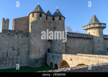 Das Château Comtal, die Burg des Grafen, ist eine mittelalterliche Burg in der Stadt Carcassonne, mit hohen Türmen und Mauern und einer Brücke zu einem befestigten Tor. Stockfoto