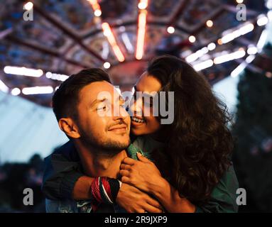 Ein junges Paar, das eine Ameisennacht im Vergnügungspark hat Stockfoto
