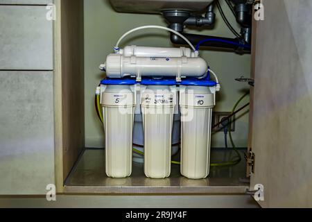 Fotografie zum Thema Wasserfiltersystem für zu Hause in der Küche im Hintergrund, Foto bestehend aus der Installation eines Wasserfiltersystems für zu Hause, Ersatzwasser Stockfoto