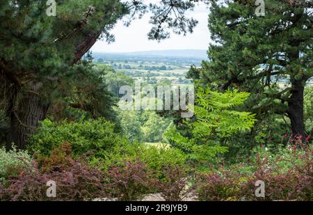 Blick durch die Bäume über den Malvern Hills von Kiftsgate Court Gardens, Gloucestershire in den Cotswolds, Großbritannien Stockfoto