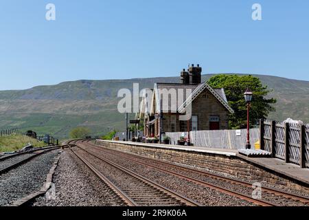 Leerer Bahnhof Ribblehead an der Carlisle-Settle-Strecke mit Whernside im Hintergrund. Sehr klarer und sonniger Tag in den Yorkshire Dales. Stockfoto