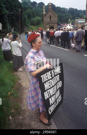 Antirömisch-Katholischer Protest. Saint Winefrides Schrein, Holywell. Mitglieder der Pfingstkirche protestieren still gegen die römisch-katholische Kirche. Römisch-katholische Prozession von der St. Winefried Kirche an ihrem Festtag am 22. Juni gehen sie zum St. Winefrides Schrein. Holywell, Flintshire Wales, Vereinigtes Königreich 1990er. HOMER SYKES Stockfoto