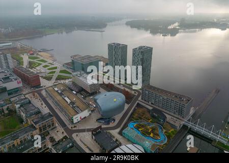 Luftdrohnenfoto von zwei Apartmentgebäuden neben einem See in Almere, Niederlande Stockfoto
